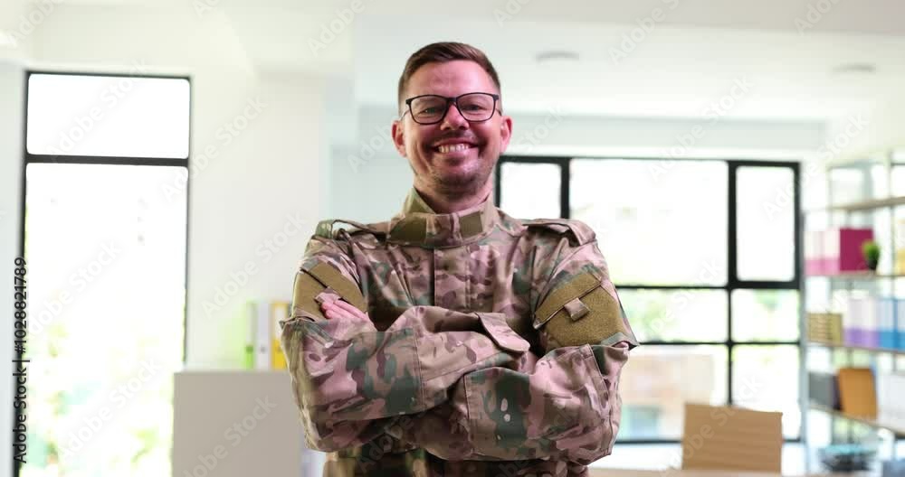 Portrait of smiling handsome young man in military uniform posing indoors. Confident caucasian recruit looking at camera Portrait of smiling handsome young man in military uniform posing indoors. Confident caucasian recruit looking at camera