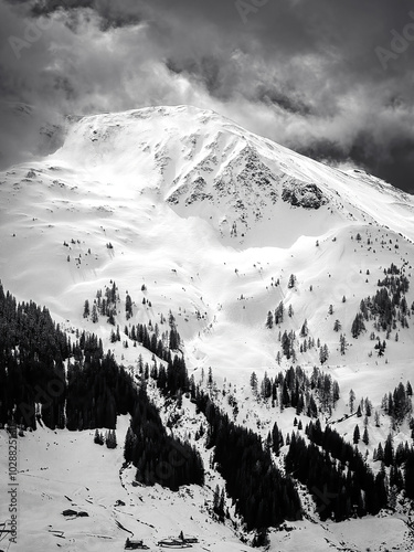 Obraz na płótnie Scenic view of snow covered mountain in the ski region of Saalbach-Hinterglemm in the Austrian alps against cloudy sky in black and white w salonie