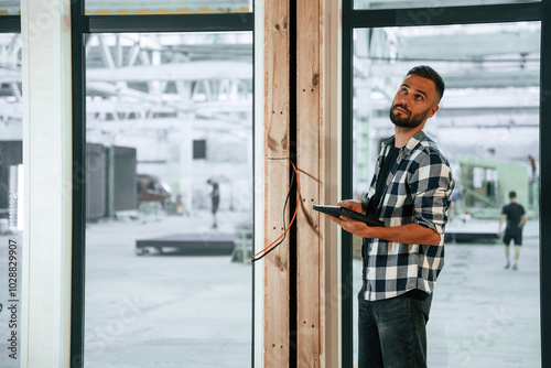 Wallpaper Mural Showing the wooden house that is under construction. Industrial worker in warehouse Torontodigital.ca