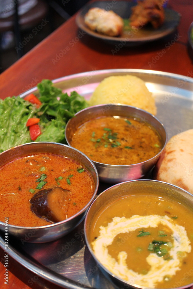 Indian cuisine: curry lunch plate (oyster and eggplant curry, chicken keema curry, dal curry, cheese kulcha, rice and salad)