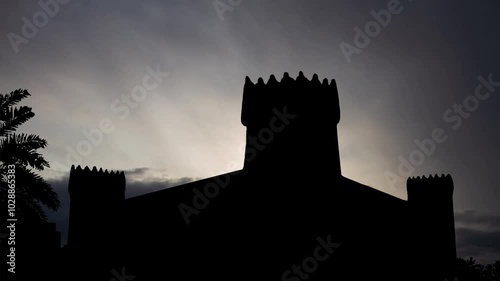 Masmak Fort in Riyadh, Time Lapse at Sunrise with Fast Clouds and Dark Silhouette of fortress, Saudi Arabia photo