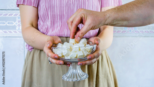 Woman holding and offering or presenting a cup of traditional Turkish delight in Ramadan / Sugar / Sacrifice Feast or Holiday. Religious Feast of Muslims. Eid Mubarak. Eid al-Adha. Feast concept photo