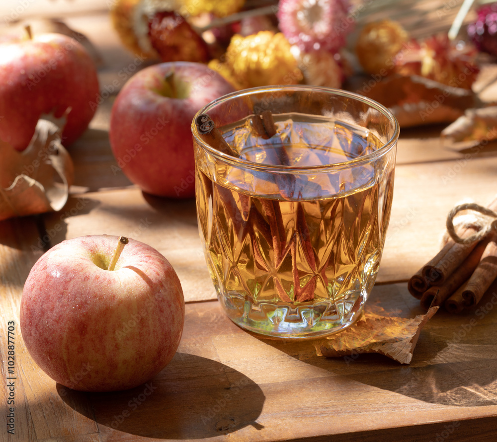 Glass of apple cider outdoors on wooden table Glass of apple cider outdoors on wooden table