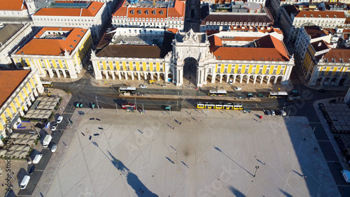 Uma imagem icónica do Terreiro do Paço (também conhecido como Praça do Comércio), situada na Baixa Pombalina, em Lisboa. A ampla praça está rodeada por majestosos edifícios de cor amarela com arcadas  photo