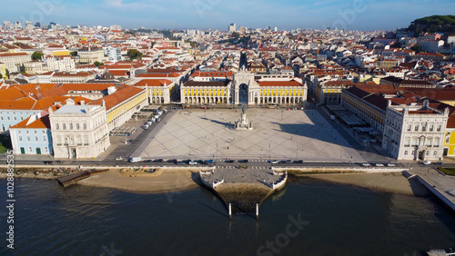 Uma imagem icónica do Terreiro do Paço (também conhecido como Praça do Comércio), situada na Baixa Pombalina, em Lisboa. A ampla praça está rodeada por majestosos edifícios de cor amarela com arcadas  photo