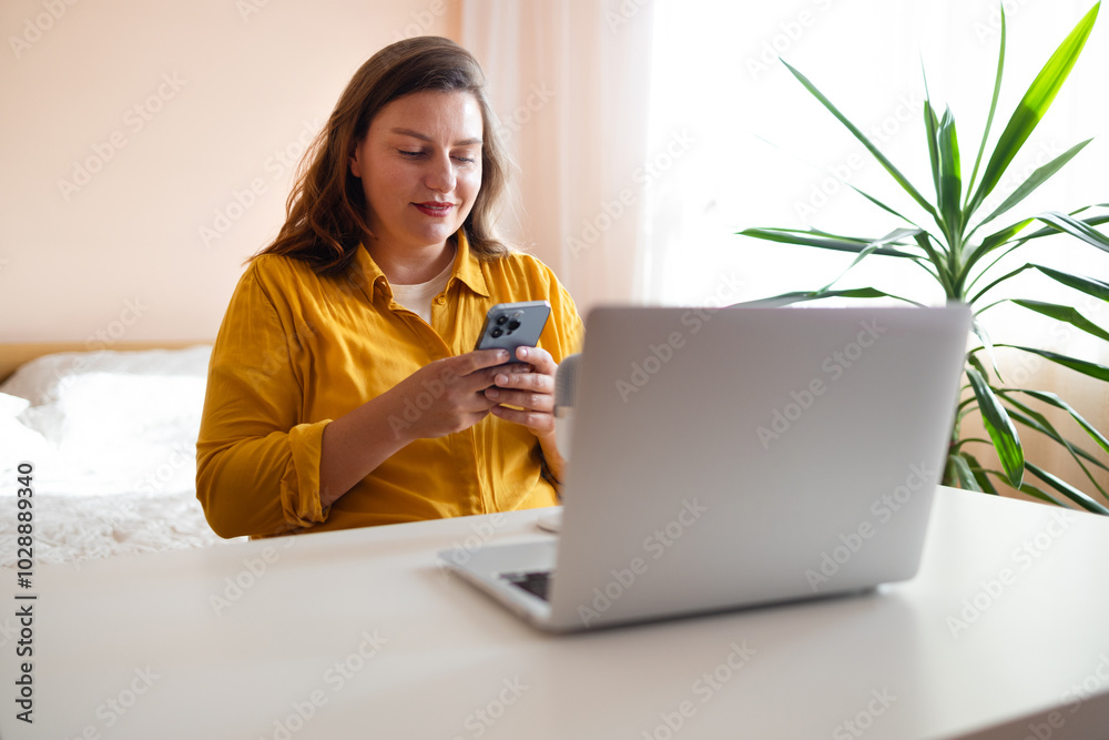 Busy professional business woman using mobile phone working in home office. Smiling female executive holding cell at desk. Happy female worker making bank payments on smartphone. High quality photo Busy professional business woman using mobile phone working in home office. Smiling female executive holding cell at desk. Happy female worker making bank payments on smartphone. High quality photo