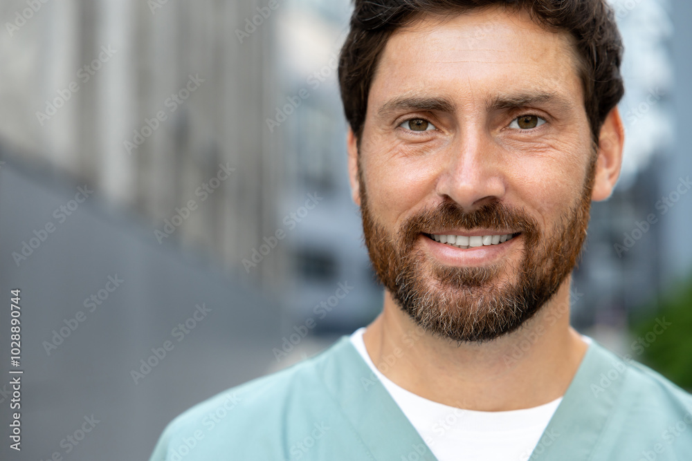 Smiling bearded man doctor in uniform standing outdoor medical center Smiling bearded man doctor in uniform standing outdoor medical center