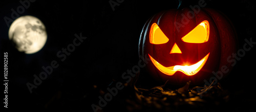 glowing jack-o-lantern under a full moon photo