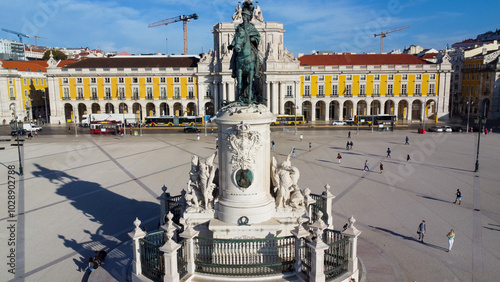 Uma imagem icónica do Terreiro do Paço (também conhecido como Praça do Comércio), situada na Baixa Pombalina, em Lisboa. A ampla praça está rodeada por majestosos edifícios de cor amarela com arcadas  photo