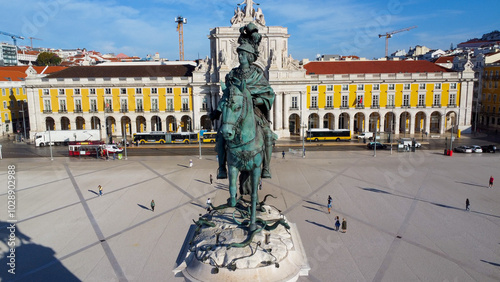 Uma imagem icónica do Terreiro do Paço (também conhecido como Praça do Comércio), situada na Baixa Pombalina, em Lisboa. A ampla praça está rodeada por majestosos edifícios de cor amarela com arcadas  photo