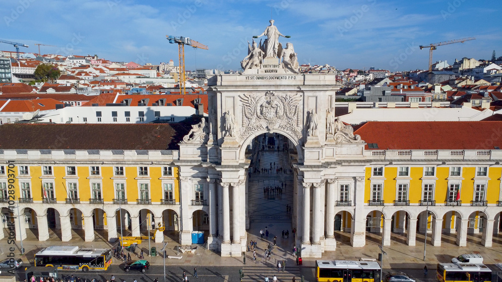 Obraz premium Uma imagem icónica do Terreiro do Paço (também conhecido como Praça do Comércio), situada na Baixa Pombalina, em Lisboa. A ampla praça está rodeada por majestosos edifícios de cor amarela com arcadas