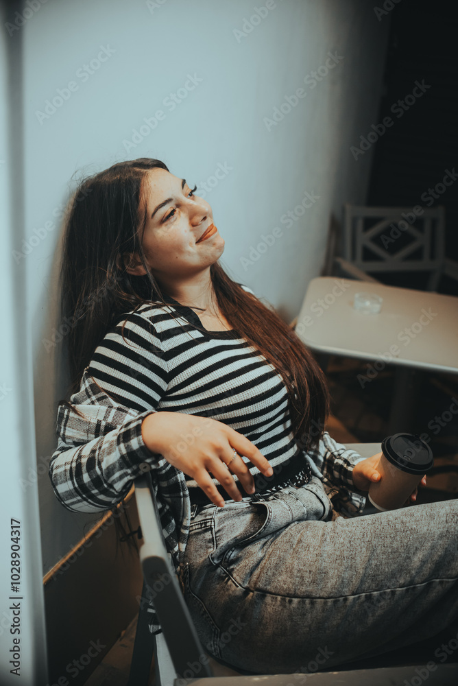 Obraz premium Cheerful Brunette Relaxing with Coffee in a Night Cafe