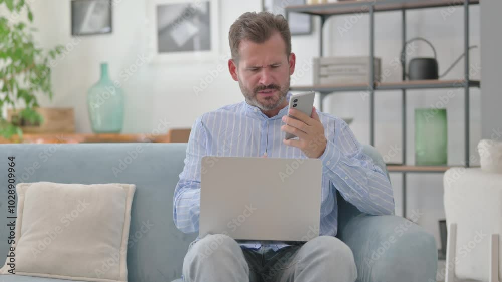 Angry Middle Aged Man Talking on Phone with Laptop in Lap Angry Middle Aged Man Talking on Phone with Laptop in Lap