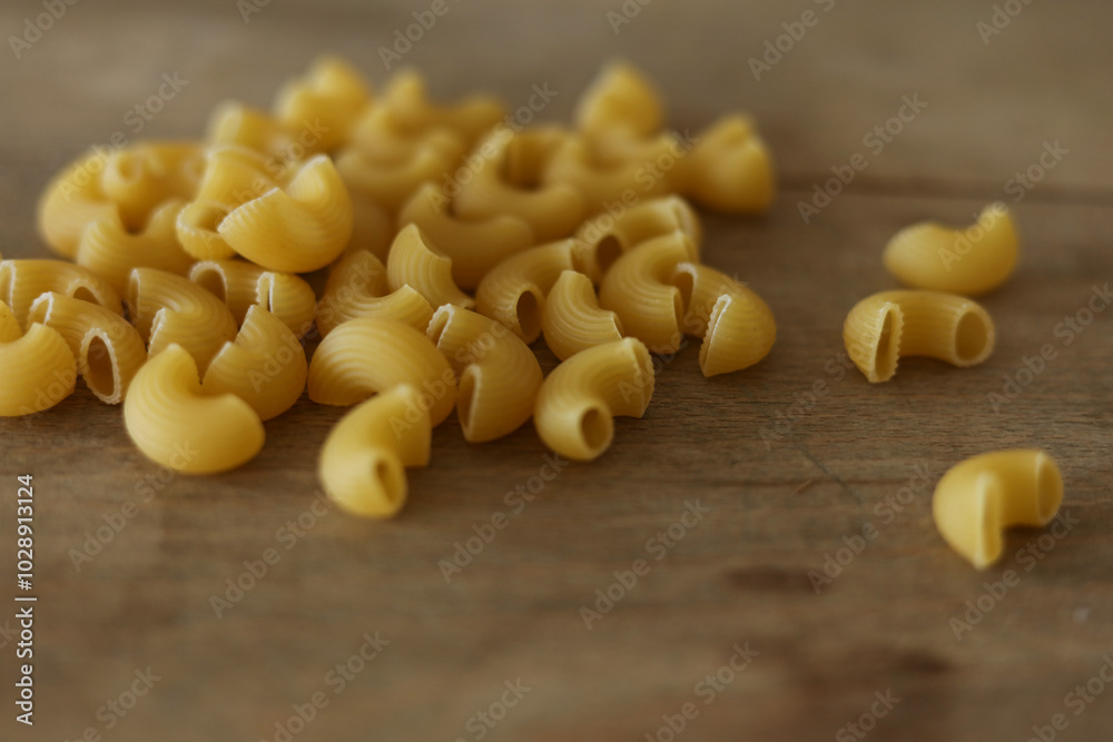 Macaroni on a wooden background. Close up. Selective focus. Macaroni on a wooden background. Close up. Selective focus.