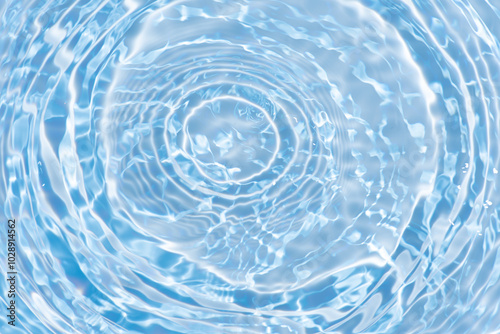 Blue water with ripples on the surface. Defocus blurred transparent blue colored clear calm water surface texture with splashes and bubbles. Water waves with shining pattern texture background.