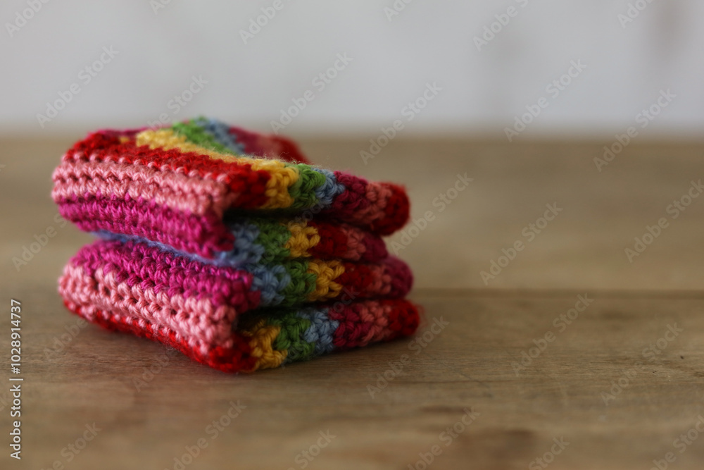 Obraz premium Colorful crochet gloves on a wooden background. Handmade. 