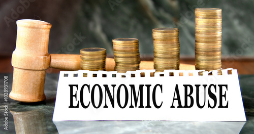 Wallpaper Mural ECONOMIC ABUSE - words on a white sheet with a judge's gavel and a stack of coins in the background Torontodigital.ca