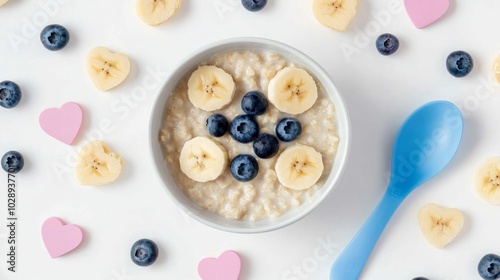 Wallpaper Mural A bowl of oatmeal with banana slices and blueberries, surrounded by hearts, banana slices and blueberries on a white background with a blue spoon. Torontodigital.ca