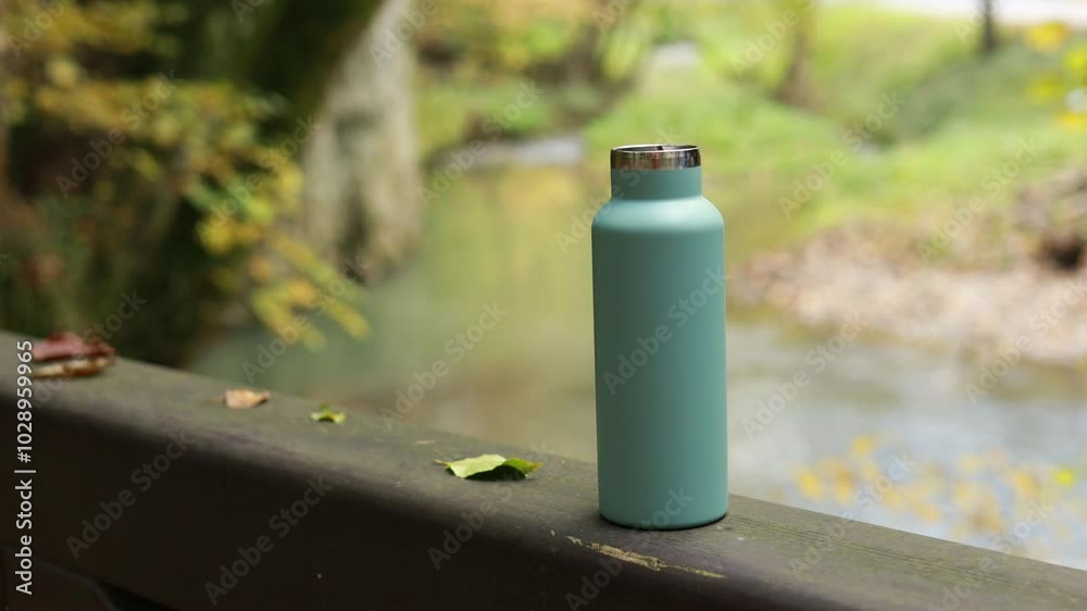 thermos with hot drink and steam from it near streaming and floating autumn river thermos with hot drink and steam from it near streaming and floating autumn river