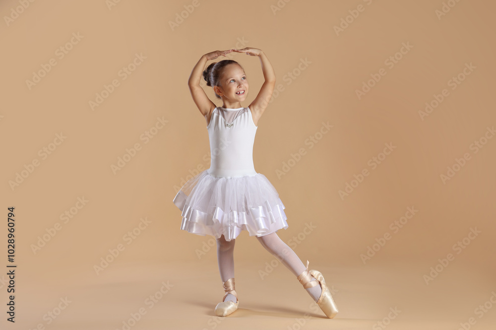 Naklejka premium Little ballerina practicing dance moves on beige background
