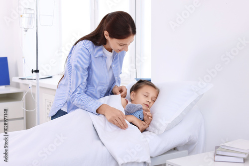 Mother and her little daughter on bed in hospital