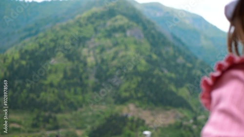 Happy child dancing against the background of mountains. Traveling with a child