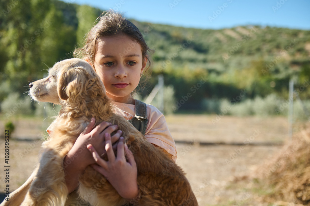 Young girl embracing a golden retriever puppy outdoors in a serene countryside setting, embodying friendship and care in an idyllic landscape. Perfect depiction of children's bond with animals. Young girl embracing a golden retriever puppy outdoors in a serene countryside setting, embodying friendship and care in an idyllic landscape. Perfect depiction of children's bond with animals.
