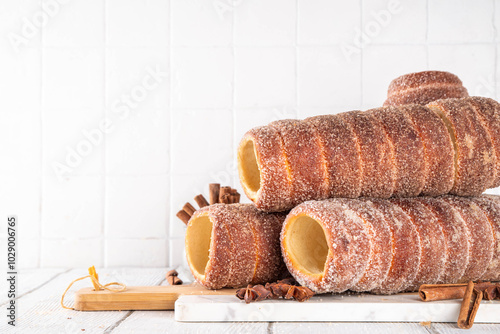 Traditional East Europe Christmas sugar glazed dessert chimney cake, trdlo or trdelnik, sweet aromatic winter seasonal street food with cinnamon and spices photo