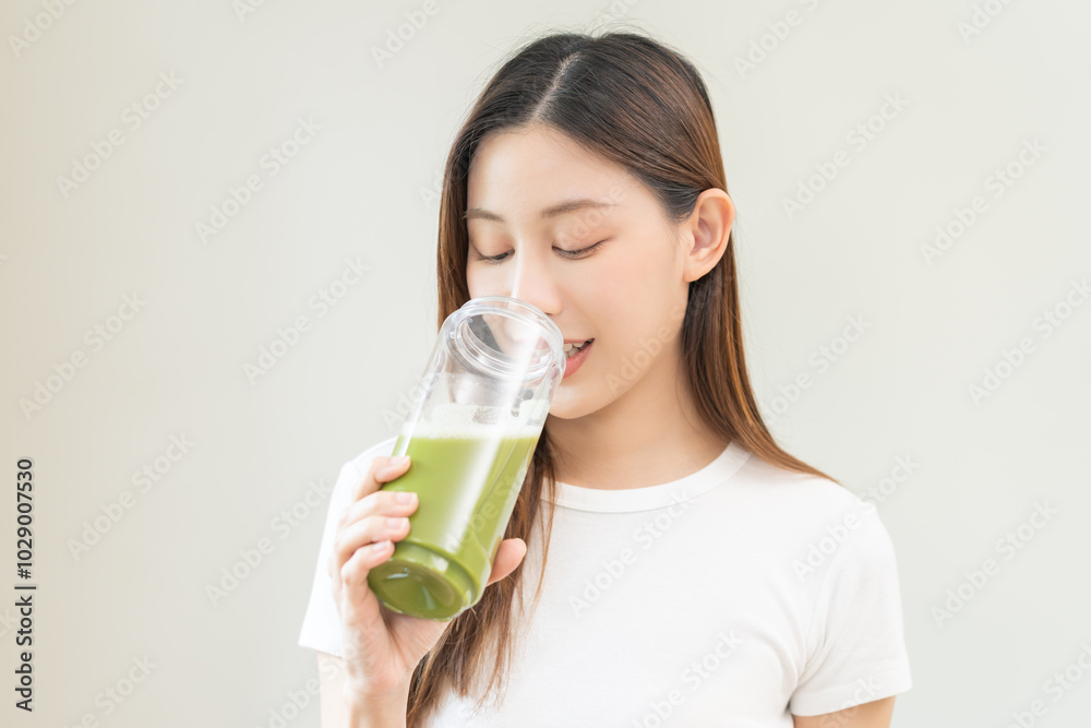 Green detox juice concept, Beautiful asian young woman hand holding vegetable smoothie bottle for diet on background. Happy girl drinking healthy meal food for weight loss. Lifestyle, vegan nutrition. Green detox juice concept, Beautiful asian young woman hand holding vegetable smoothie bottle for diet on background. Happy girl drinking healthy meal food for weight loss. Lifestyle, vegan nutrition.