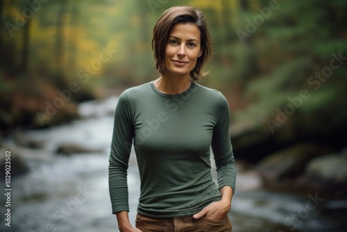 Portrait of a tender woman in her 40s sporting a long-sleeved thermal undershirt in tranquil forest stream