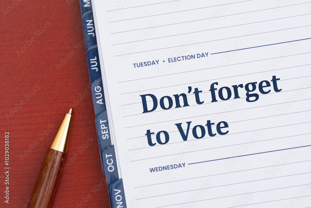 Do not forget to vote message on a Tuesday day planner with pen on desk Do not forget to vote message on a Tuesday day planner with pen on desk