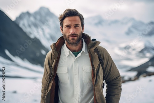 Portrait of a merry man in his 30s sporting a breathable hiking shirt on pristine snowy mountain