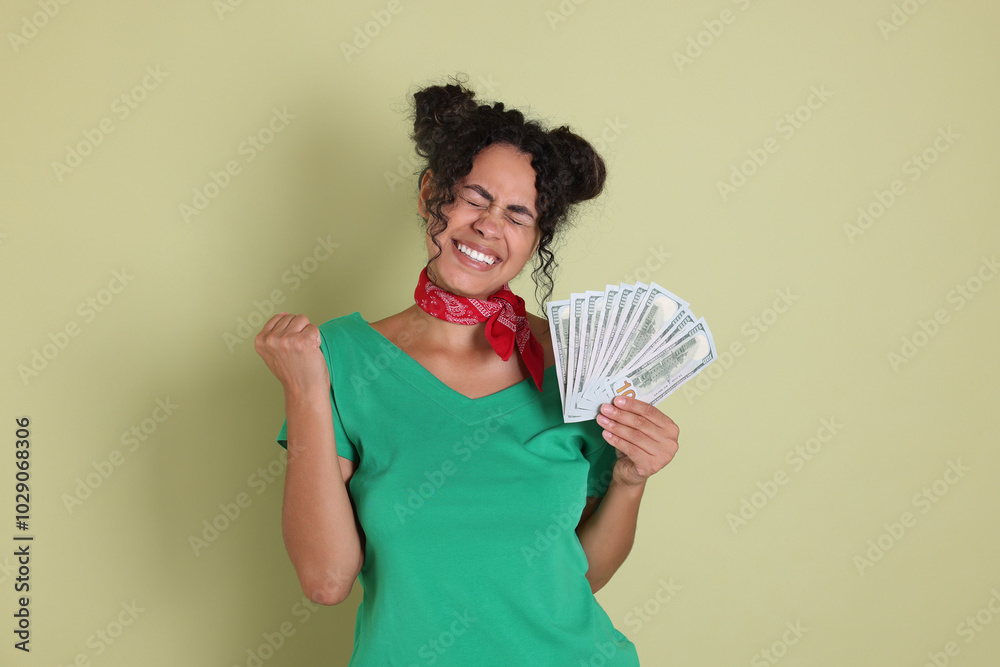 Happy woman with dollar banknotes on pale green background Happy woman with dollar banknotes on pale green background