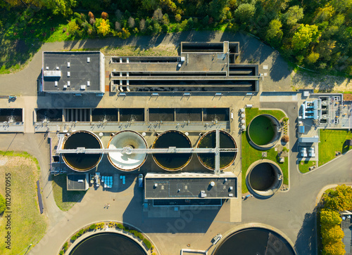 A large water treatment plant with four tanks and a large green area