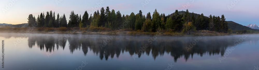 Photograph of water with reflections of mountains