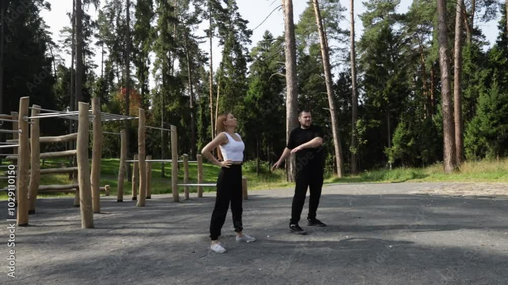 Workout, man and woman doing sports outdoors, active fitness training in a park, summer exercise with equipment, street workout with a trainer. Workout, man and woman doing sports outdoors, active fitness training in a park, summer exercise with equipment, street workout with a trainer.
