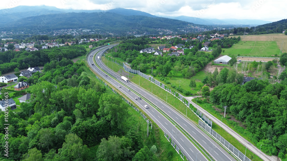 Fototapeta premium Highway through rural landscape with hills and mountains