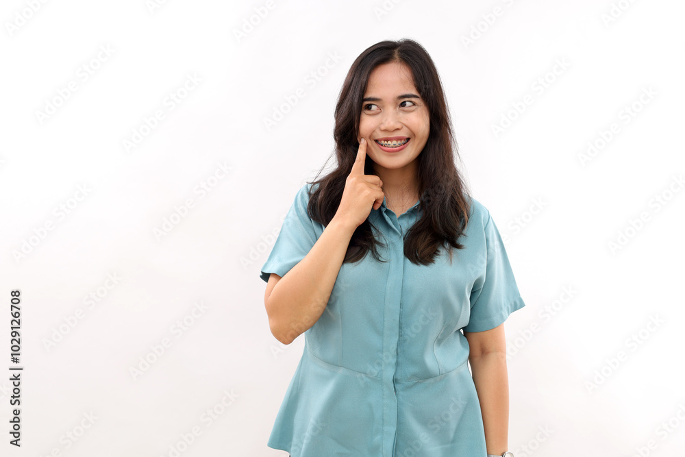 Pretty young woman with Asian appearance, wears casual shirt looks aside, models against white background, blank space for promo. Emotions and beauty concept Pretty young woman with Asian appearance, wears casual shirt looks aside, models against white background, blank space for promo. Emotions and beauty concept