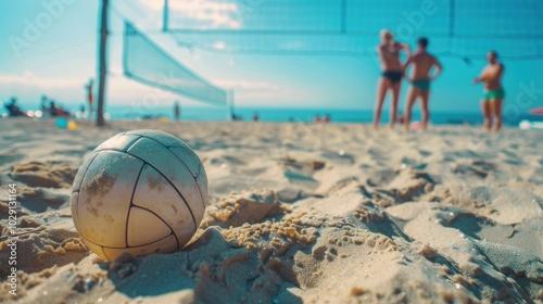 Fototapeta Naklejka Na Ścianę i Meble -  Beach volleyball sport. Close up of ball on the beach with volleyball net and players in the background, summer sport