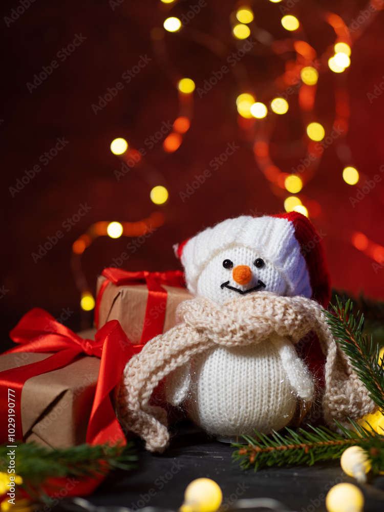 Obraz premium snowman and Christmas gift boxes on a red background. Copy space
