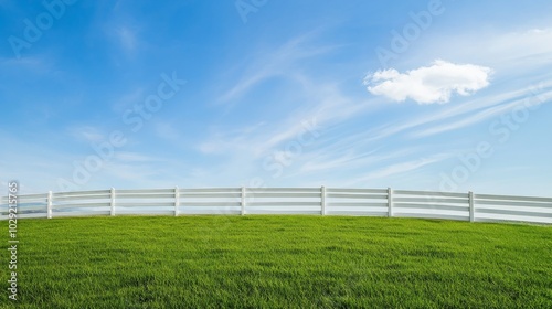 A white fence outlines a green meadow, all under a brilliant blue sky.