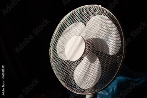 Three-bladed fan in a protective mesh.