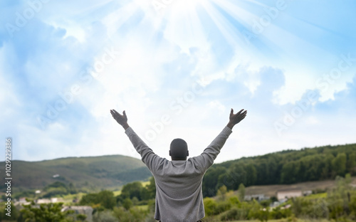 Praising the lord. A man with his arms raised to the sky in thankfulness and prayer. Themes such as Embrace, Deliverer, Rescuer, Freedom, Protected, Reflecting