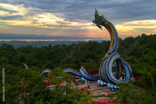 Aerial view of Phaya Sri Mukda Mahamuni Nilotpala Nakkharat The King of giant Naga statue at Wat Phu Manorom in sunrise, Mukdahan Province Thailand,