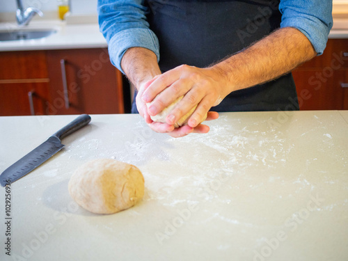 young man kneading a wheat flour dough