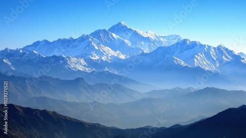 Snow-covered mountains under a clear blue sky, with soft light highlighting the peaks