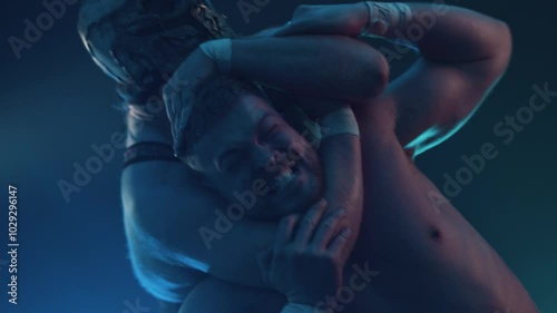 Masked pro wrestler puts his opponent in a choke hold