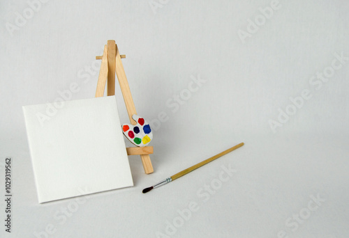 Mini easel with white blank canvas. Art concept. White background. photo