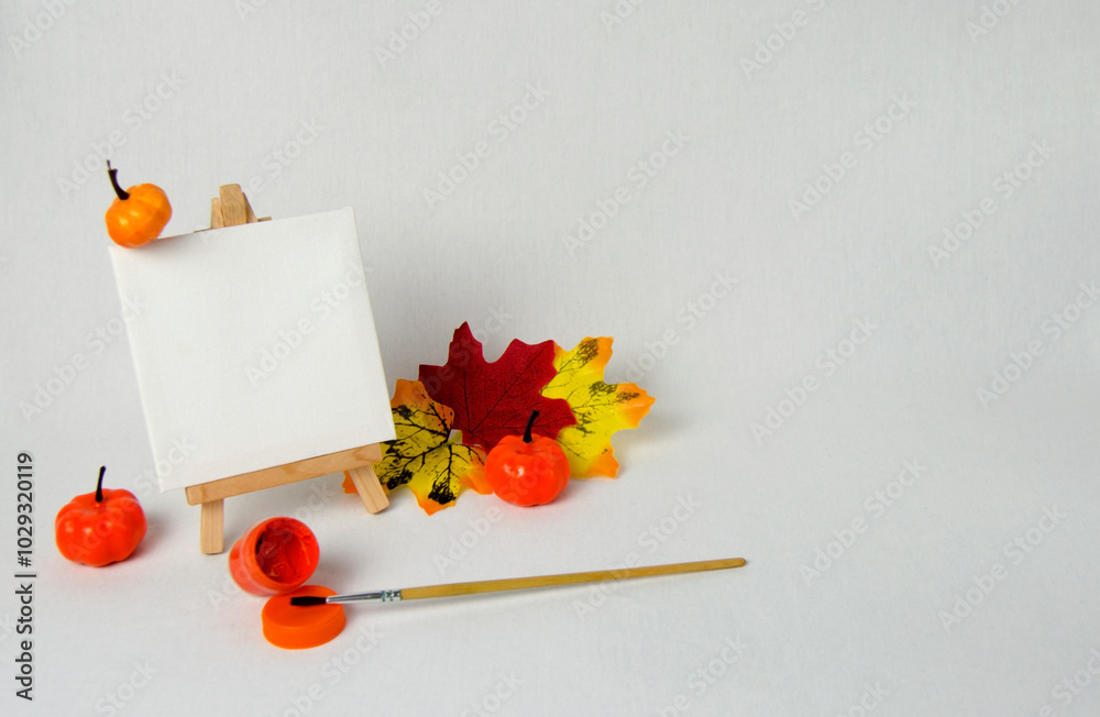 Mini easel with white blank canvas. Art concept.Halloween concept. Autumn concept. White background. Mini easel with white blank canvas. Art concept.Halloween concept. Autumn concept. White background.