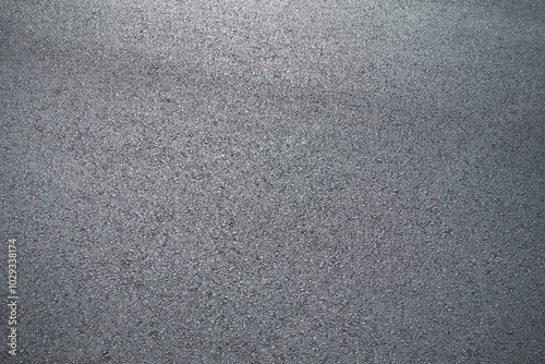 A close-up view of a gray, grainy surface with a textured appearance, resembling rough concrete or asphalt. The image shows a uniform, speckled pattern across the entire frame